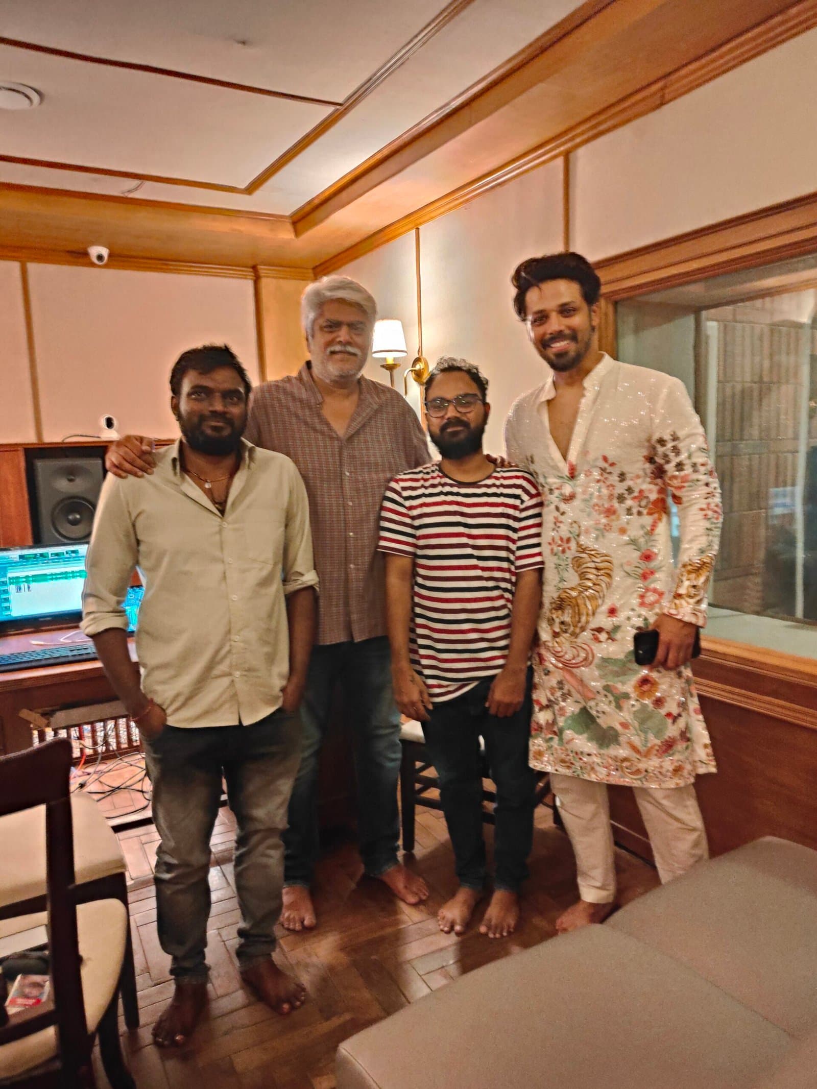 A director, composer and actors standing together in the control room